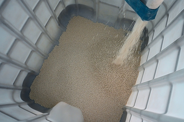 Plastic pellets pour into a bin